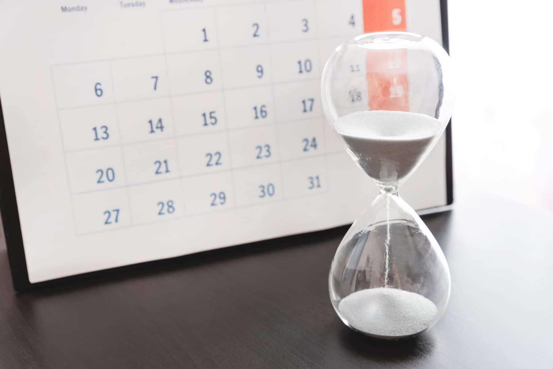 calendar and sand timer on desk